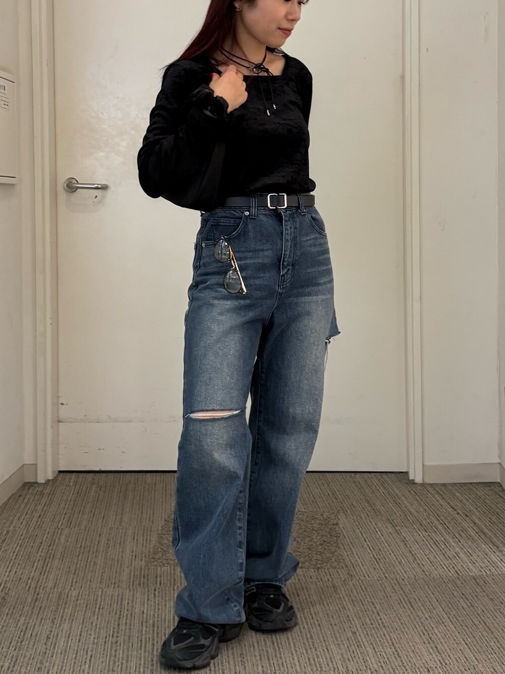 ブルー系のデニムパンツ、ブラック系のハンドバッグ、ブラック系のTシャツ/カットソーを着用したレディースの秋コーディネートの3枚目の写真