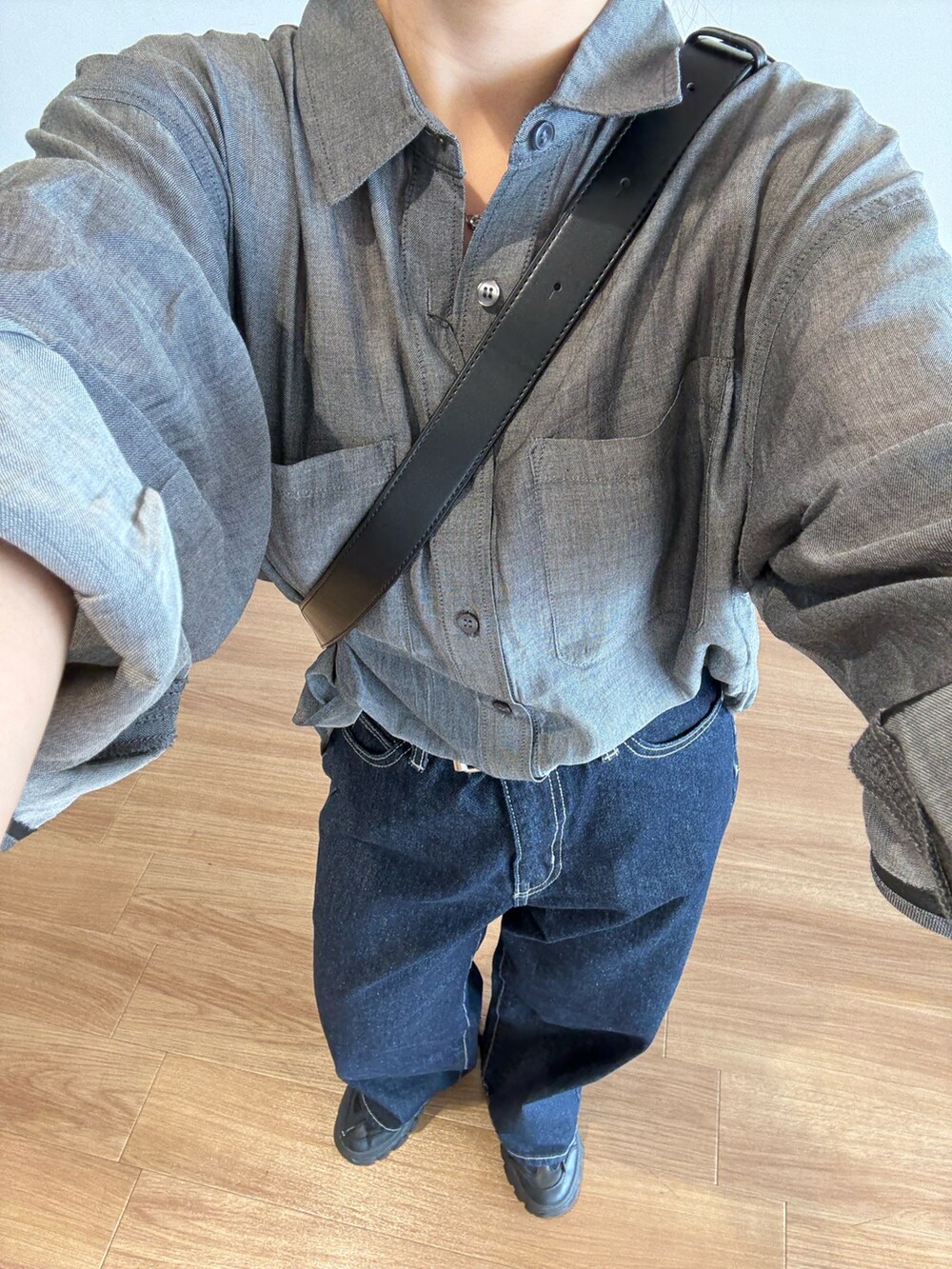 ブルー系のデニムパンツ、ブラック系のボディバッグ/ウエストポーチ、ブラック系のシャツ/ブラウスを着用したレディースの夏コーディネートの4枚目の写真