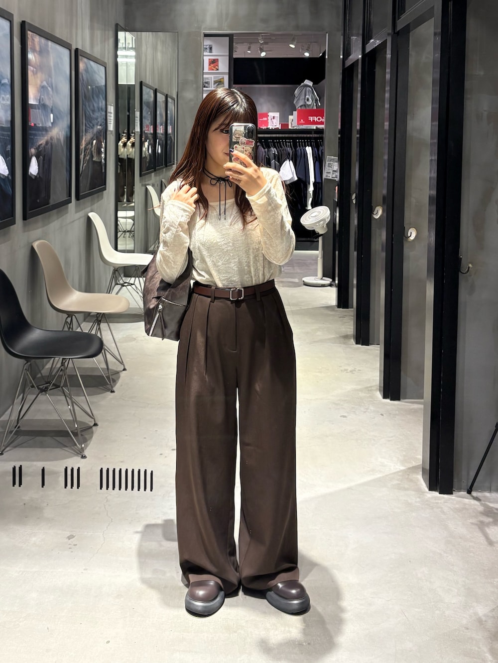 ブラウン系のスラックス、ホワイト系のTシャツ/カットソー、ブラウン系のショルダーバッグを着用したレディースの秋コーディネートの3枚目の写真