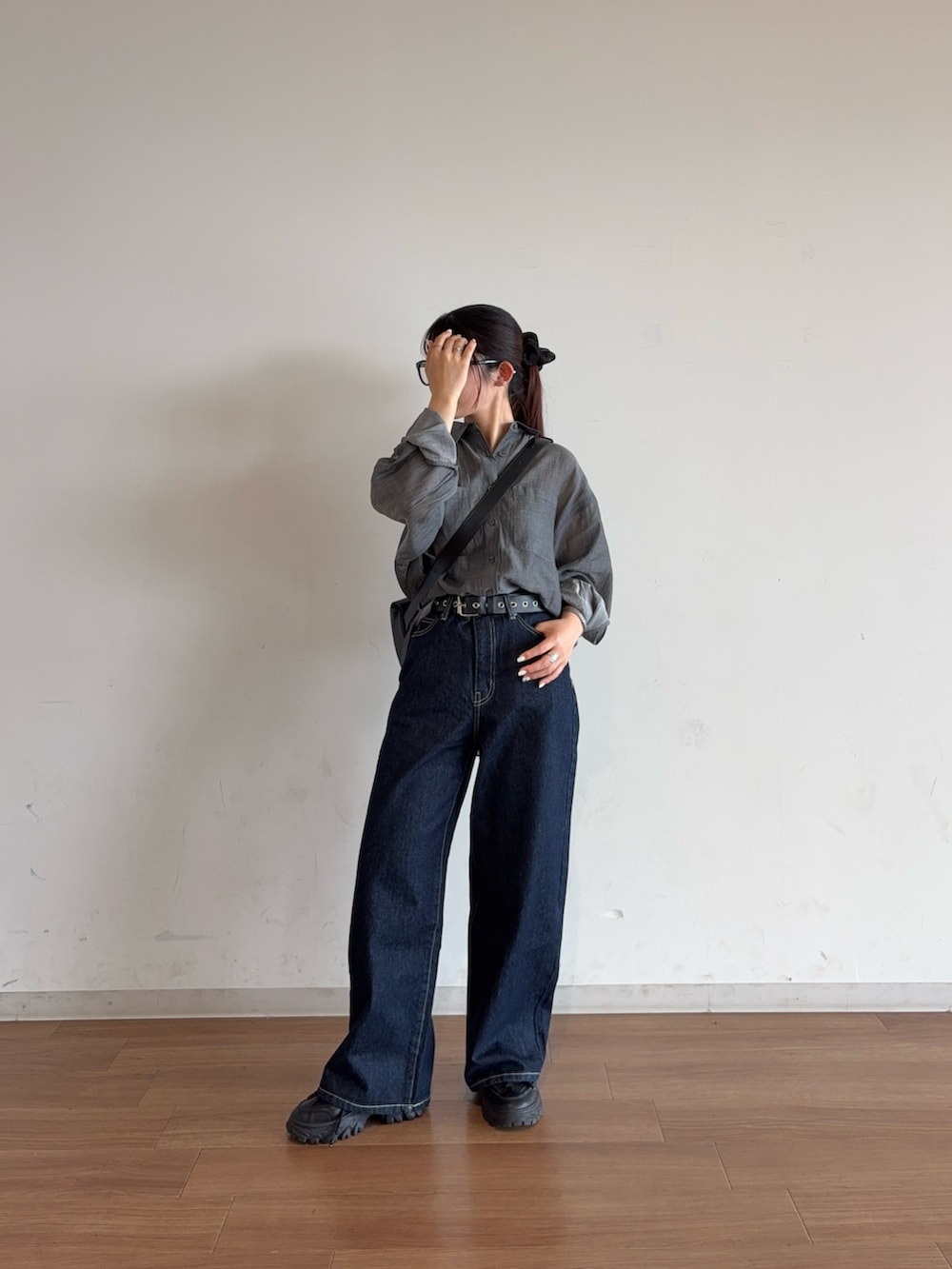 ブルー系のデニムパンツ、ブラック系のボディバッグ/ウエストポーチ、ブラック系のシャツ/ブラウスを着用したレディースの夏コーディネートの2枚目の写真