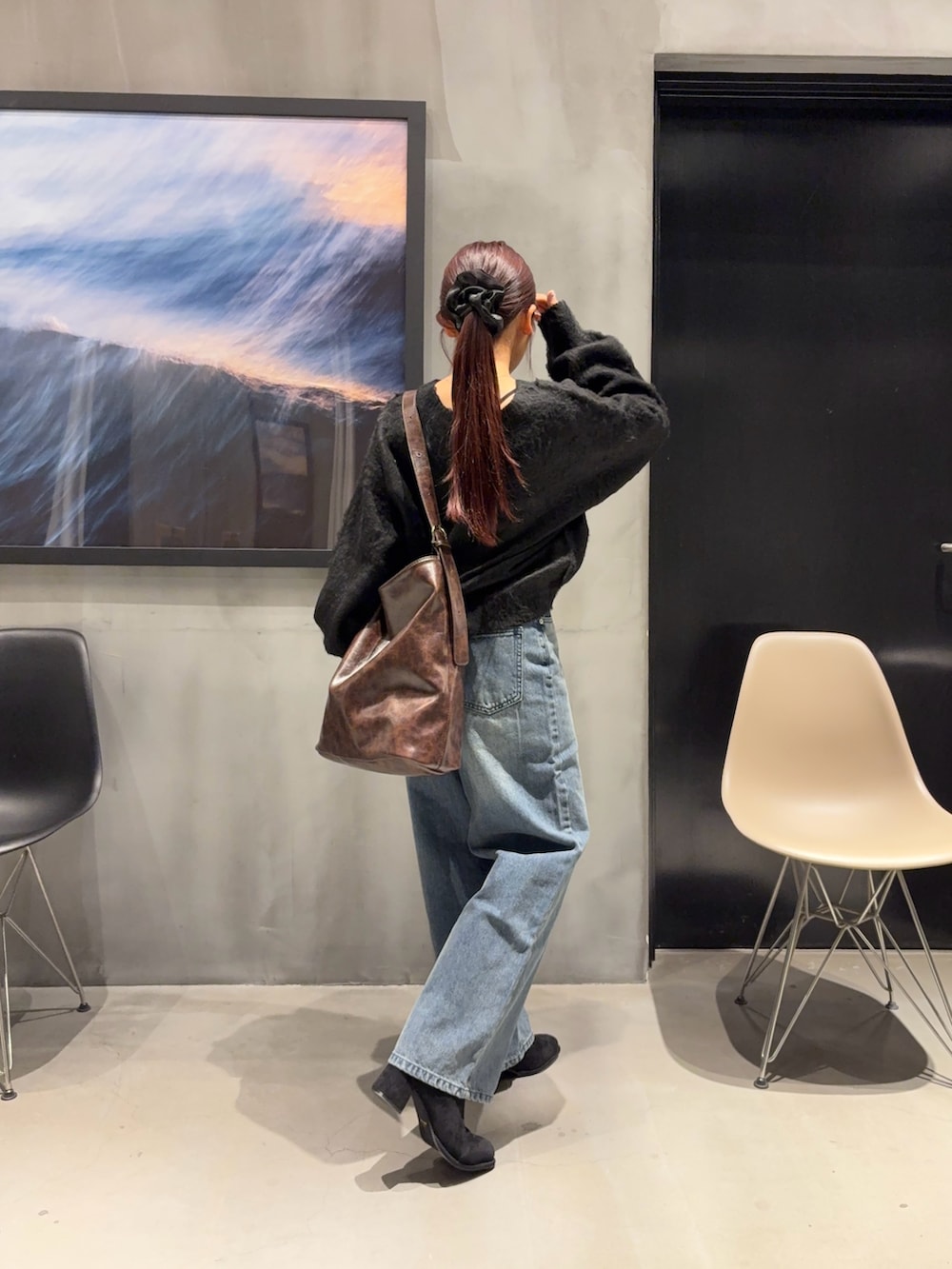 ブルー系のデニムパンツ、ブラック系のブーツ、ブラック系のニット/セーターを着用したレディースの冬コーディネートの3枚目の写真