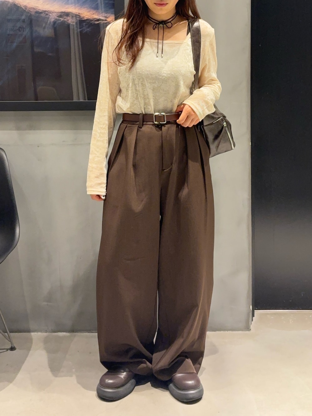 ブラウン系のスラックス、ホワイト系のTシャツ/カットソー、ブラウン系のショルダーバッグを着用したレディースの秋コーディネートの4枚目の写真