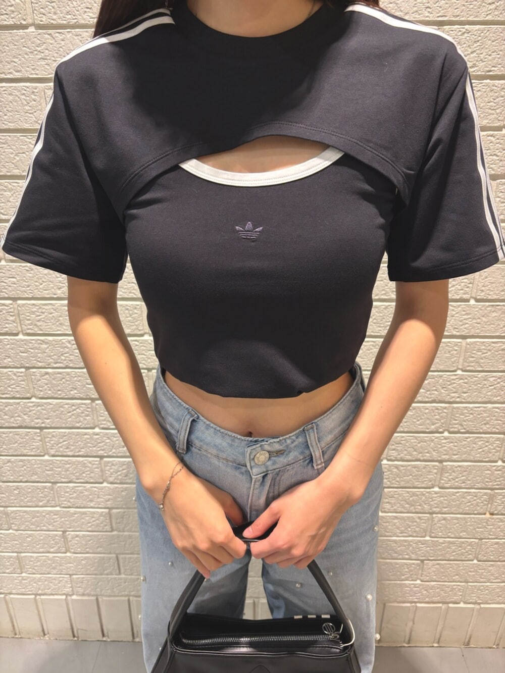 ブラック系のTシャツ/カットソー、ピンク系のスニーカー、ブラック系のショルダーバッグを着用したレディースの夏コーディネートの2枚目の写真