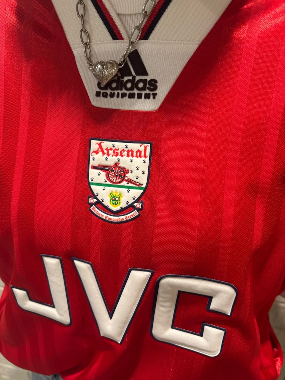 レッド系のトップス、ブラウン系のスニーカー、ブラック系のアクセサリーを着用したレディースの秋コーディネートの3枚目の写真