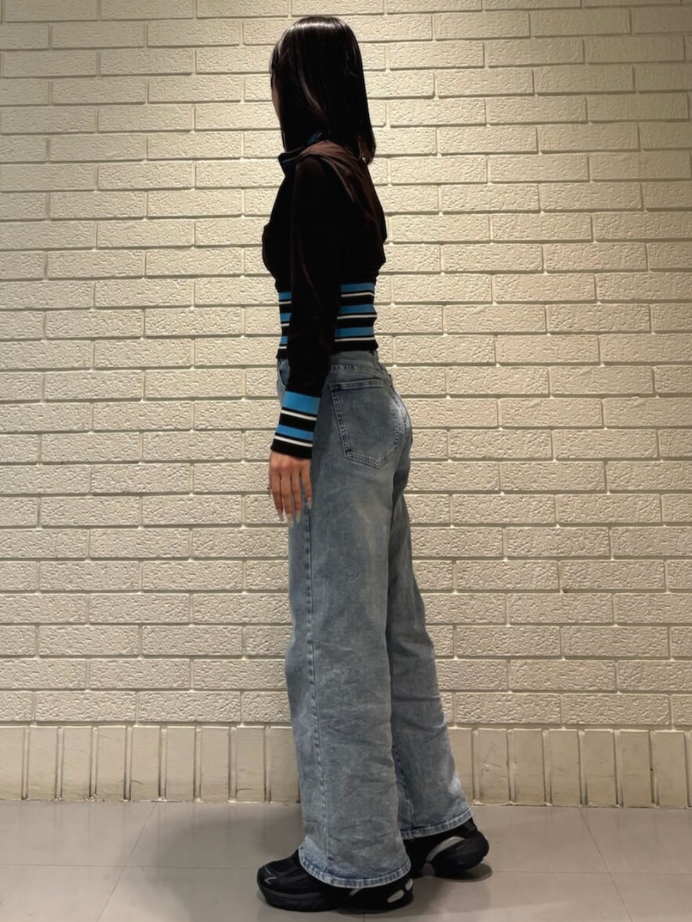 ブラウン系のジャージ、ブラック系のスニーカーを着用したレディースの冬コーディネートの2枚目の写真