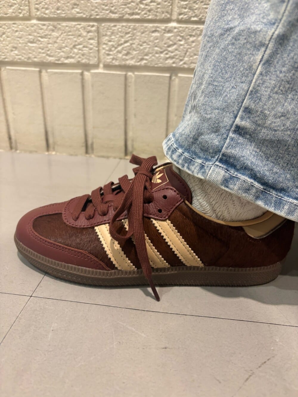 レッド系のトップス、ブラウン系のスニーカー、ブラック系のアクセサリーを着用したレディースの秋コーディネートの4枚目の写真