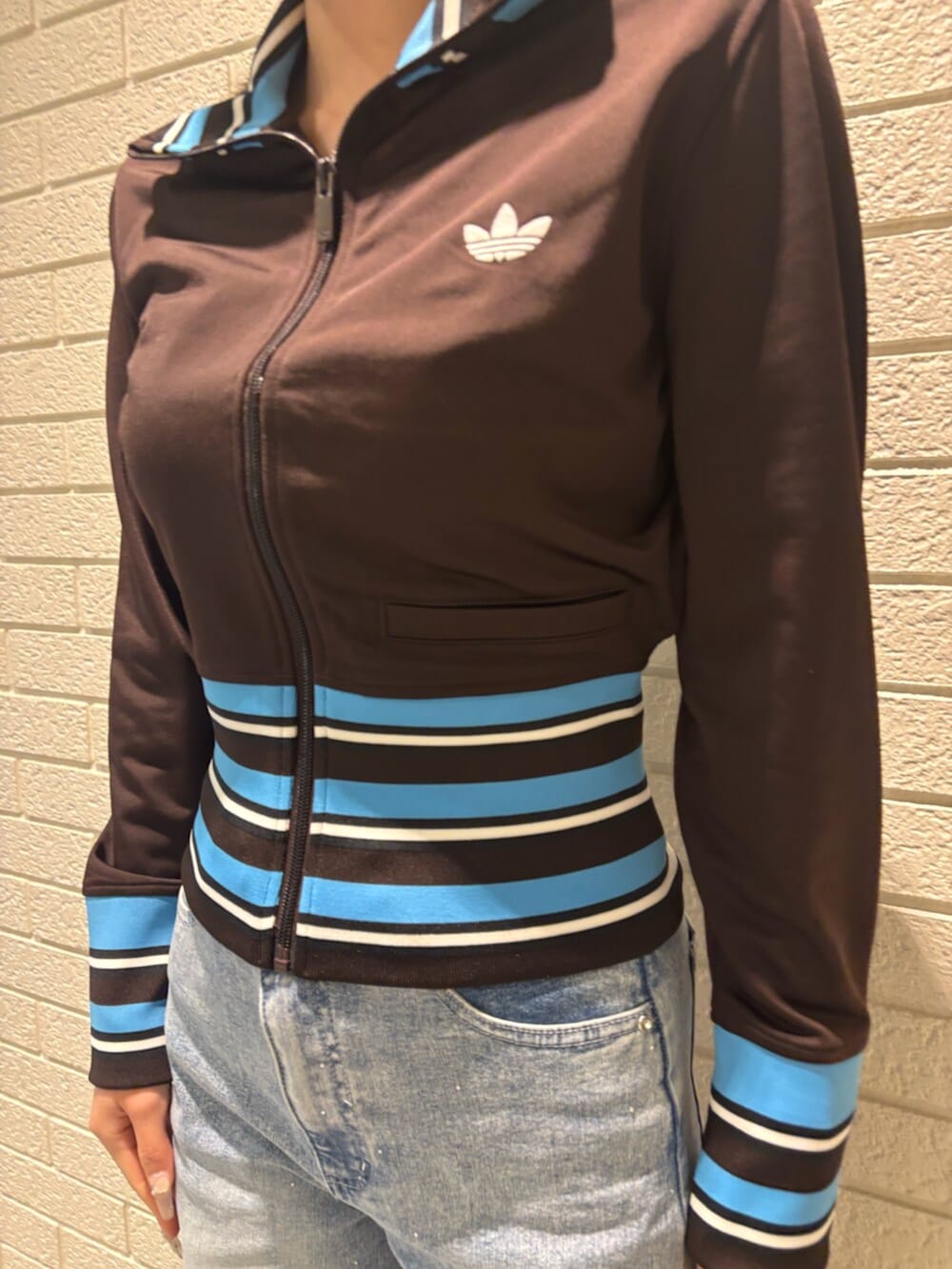 ブラウン系のジャージ、ブラック系のスニーカーを着用したレディースの冬コーディネートの3枚目の写真