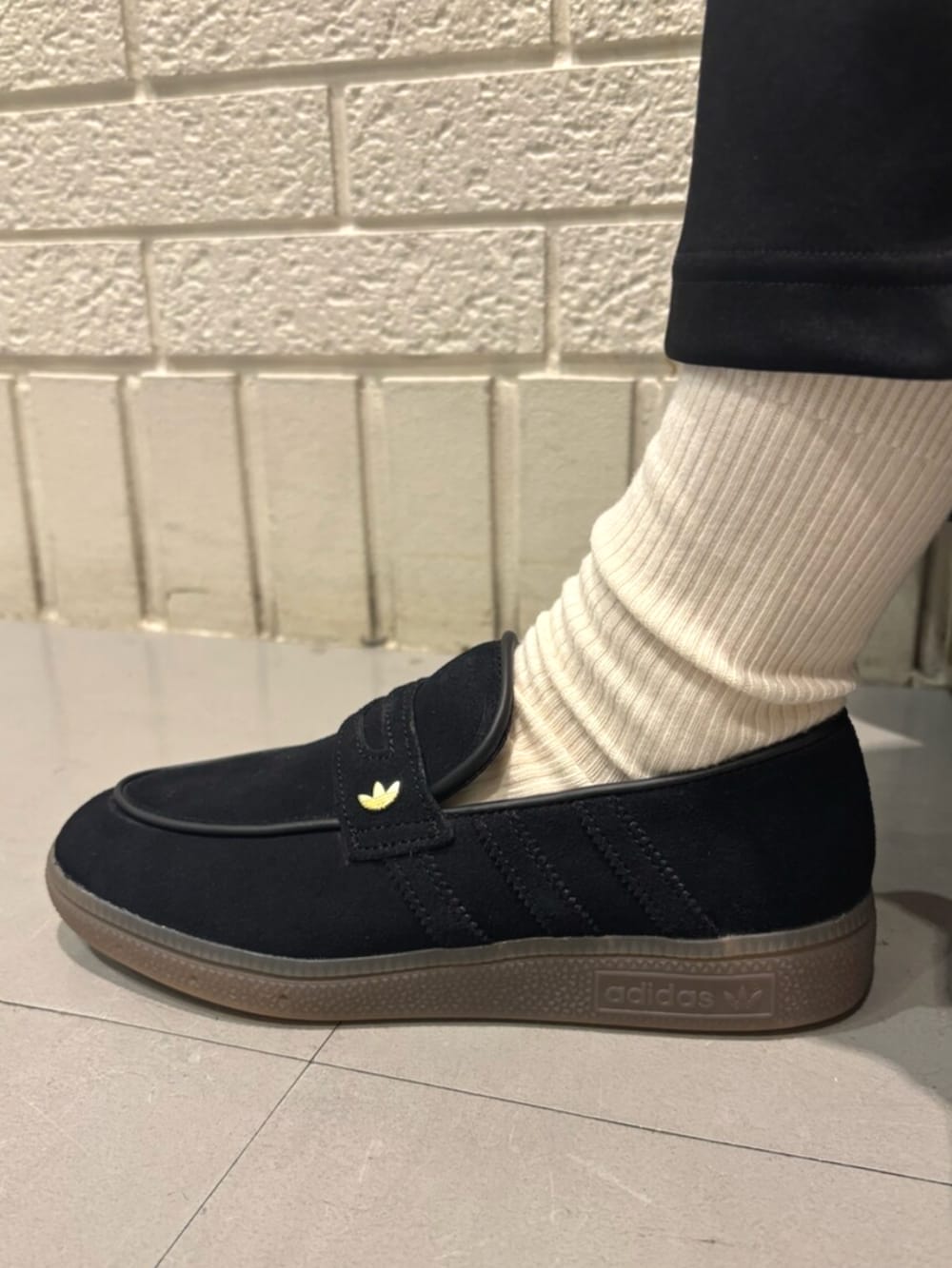 ブラック系のスカート、ブラック系のスニーカー、ブラウン系のショルダーバッグを着用したレディースの冬コーディネートの4枚目の写真