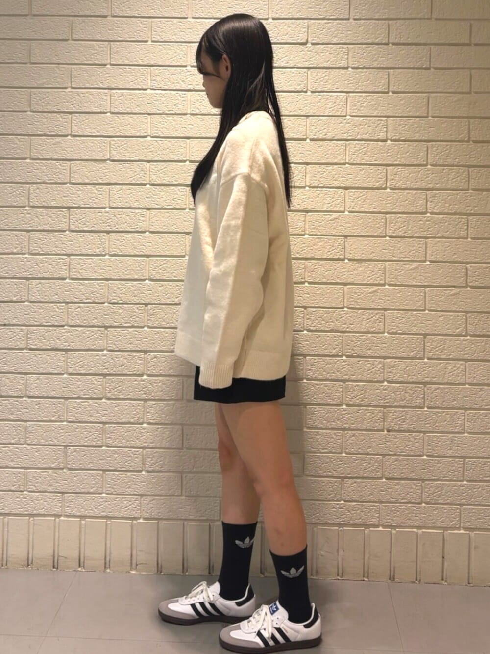 ホワイト系のニット/セーター、ホワイト系のシューズ、ブラック系のソックス/靴下を着用したレディースの秋コーディネートの2枚目の写真