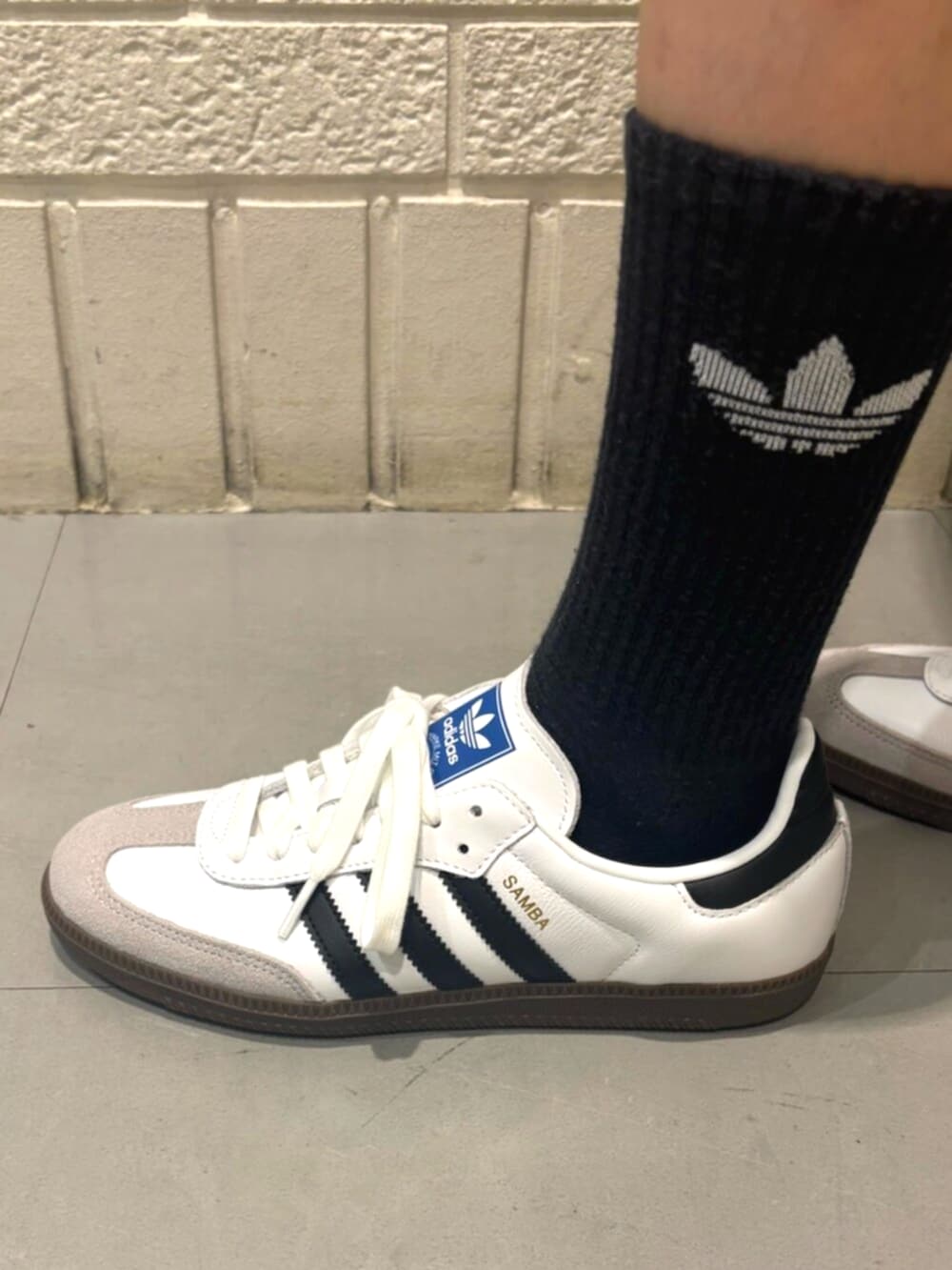 ホワイト系のニット/セーター、ホワイト系のシューズ、ブラック系のソックス/靴下を着用したレディースの秋コーディネートの4枚目の写真