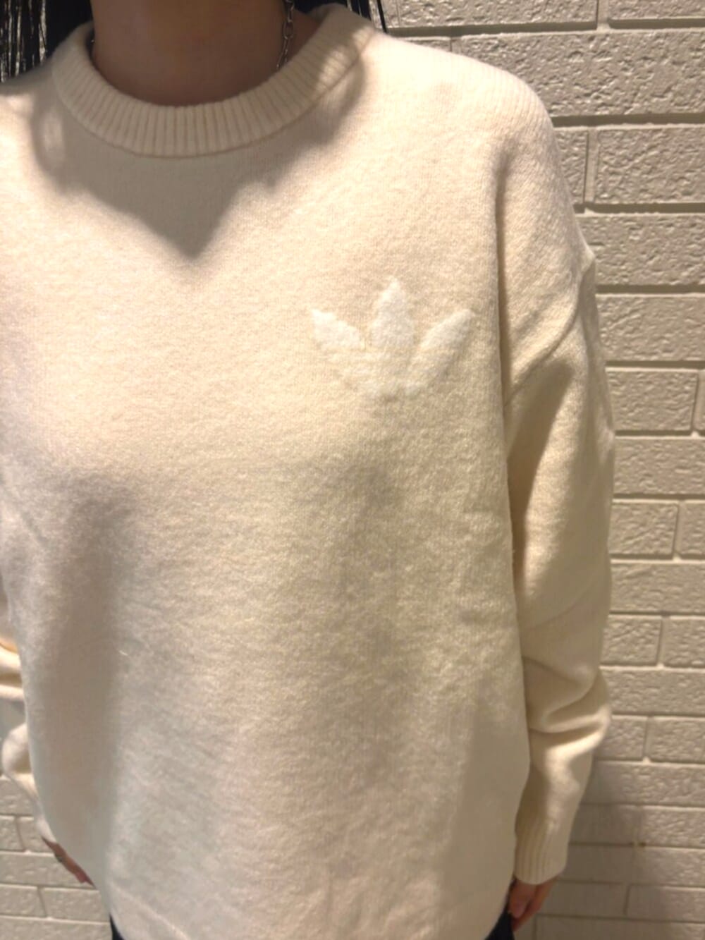 ホワイト系のニット/セーター、ホワイト系のシューズ、ブラック系のソックス/靴下を着用したレディースの秋コーディネートの3枚目の写真