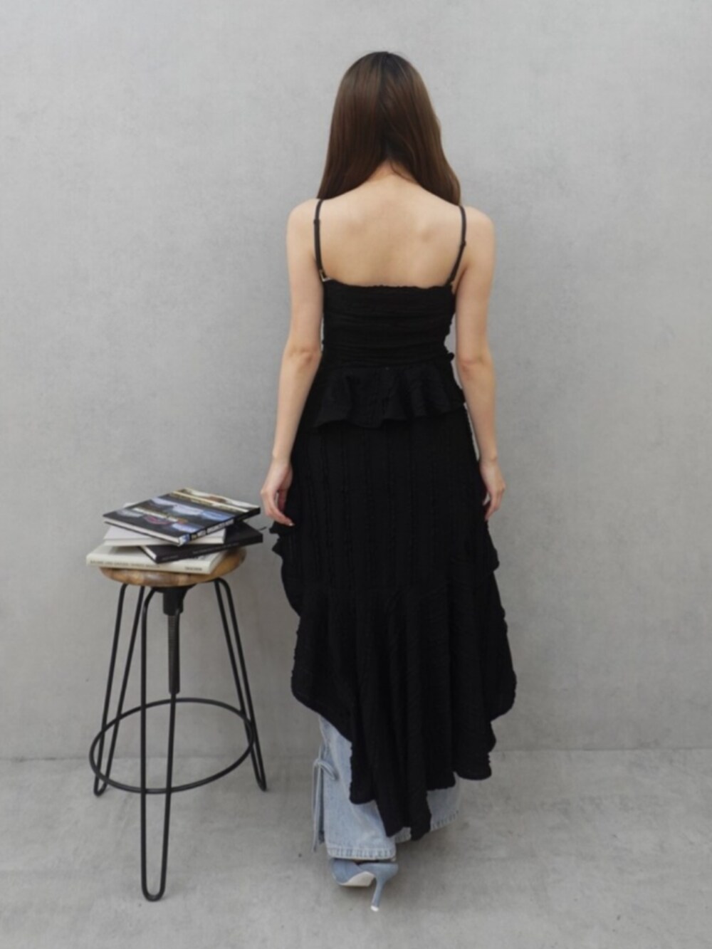 ブラック系のワンピース、ブルー系のデニムパンツ、ブルー系のサンダルを着用したレディースの春コーディネートの3枚目の写真