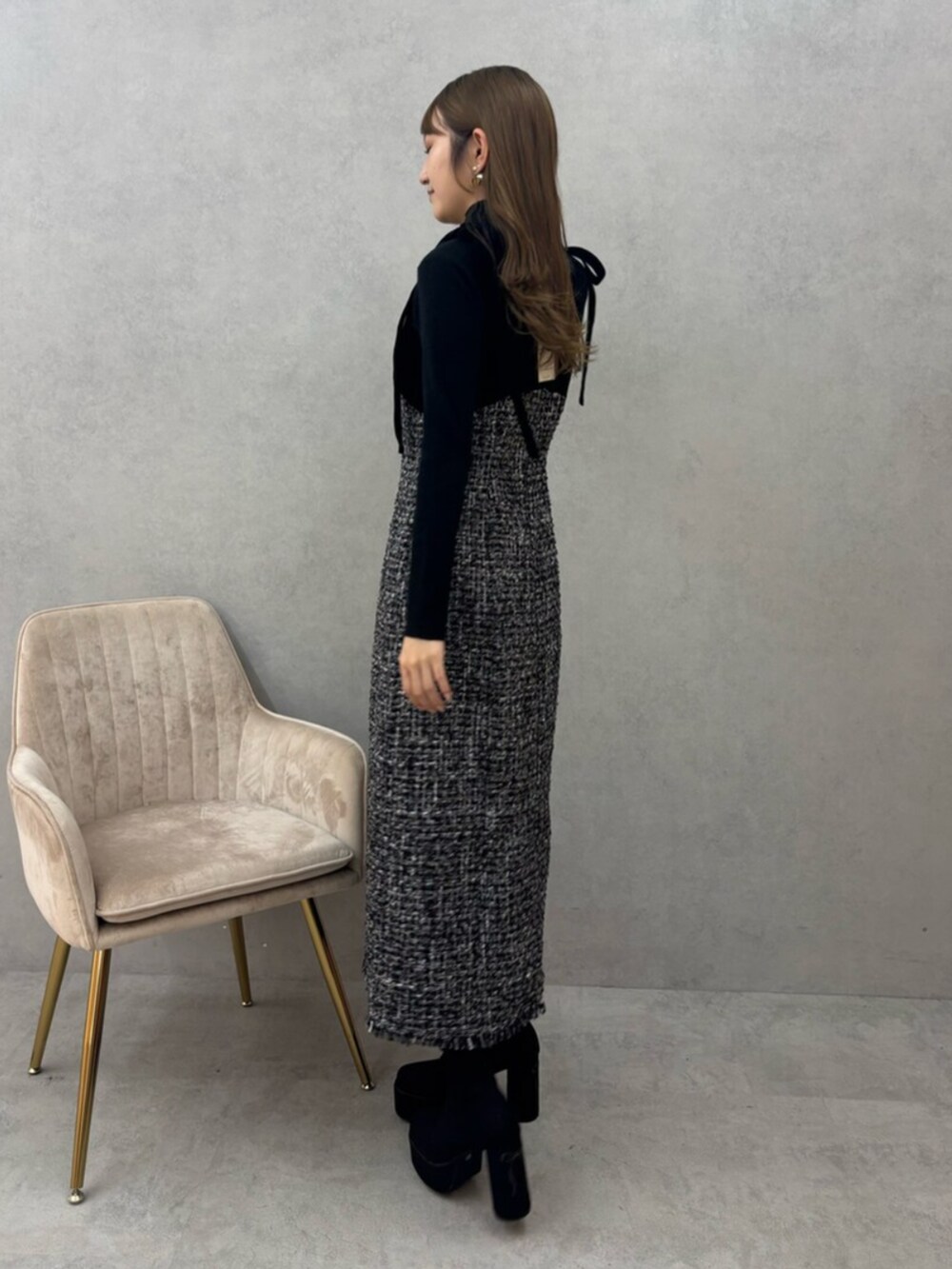 ブラック系のブーツ、ブラック系のワンピースを着用したレディースの秋コーディネートの2枚目の写真