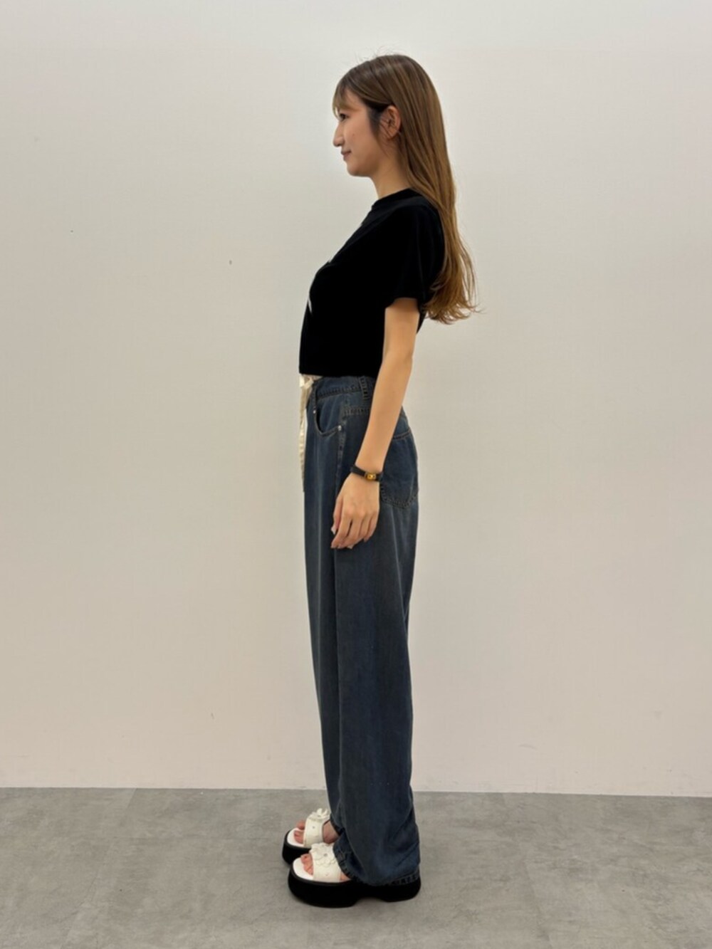 ブラック系のTシャツ/カットソー、ブルー系のデニムパンツ、ホワイト系のサンダルを着用したレディースの夏コーディネートの5枚目の写真