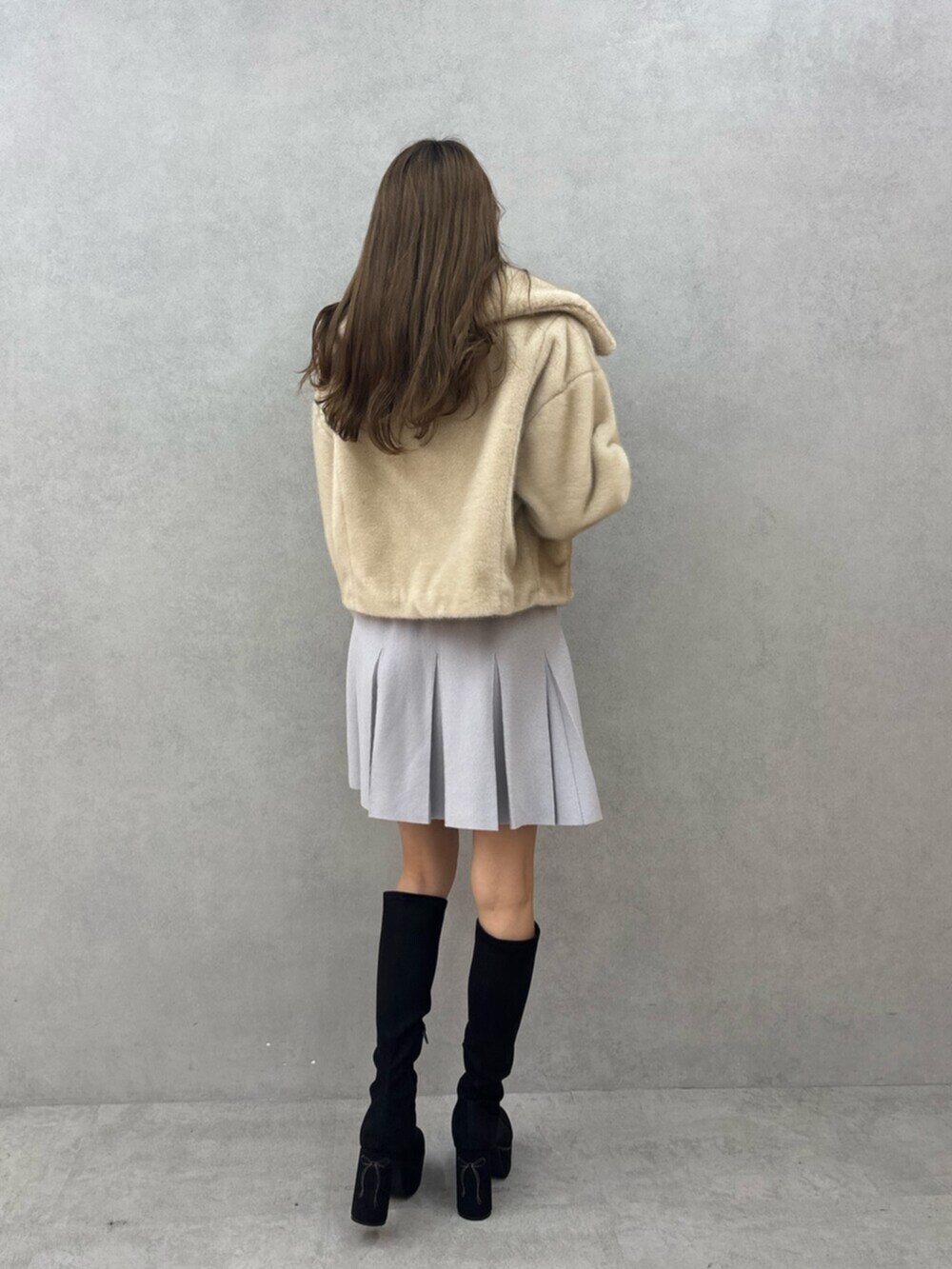 ブラック系のブーツ、ベージュ系のブルゾン、グレー系のワンピースを着用したレディースの秋コーディネートの3枚目の写真