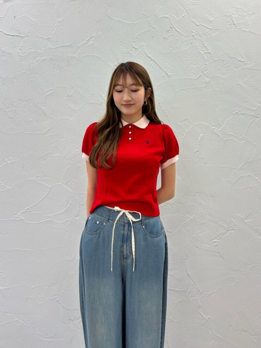 ブラック系のサンダル、ブルー系のデニムパンツ、レッド系のポロシャツを着用したレディースの夏コーディネートの8枚目の写真