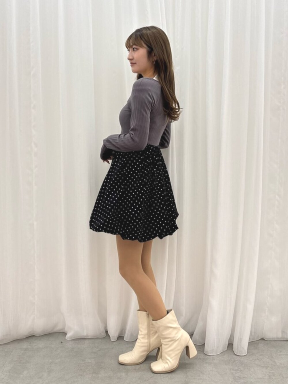 ホワイト系のブーツ、グレー系のワンピースを着用したレディースの冬コーディネートの3枚目の写真