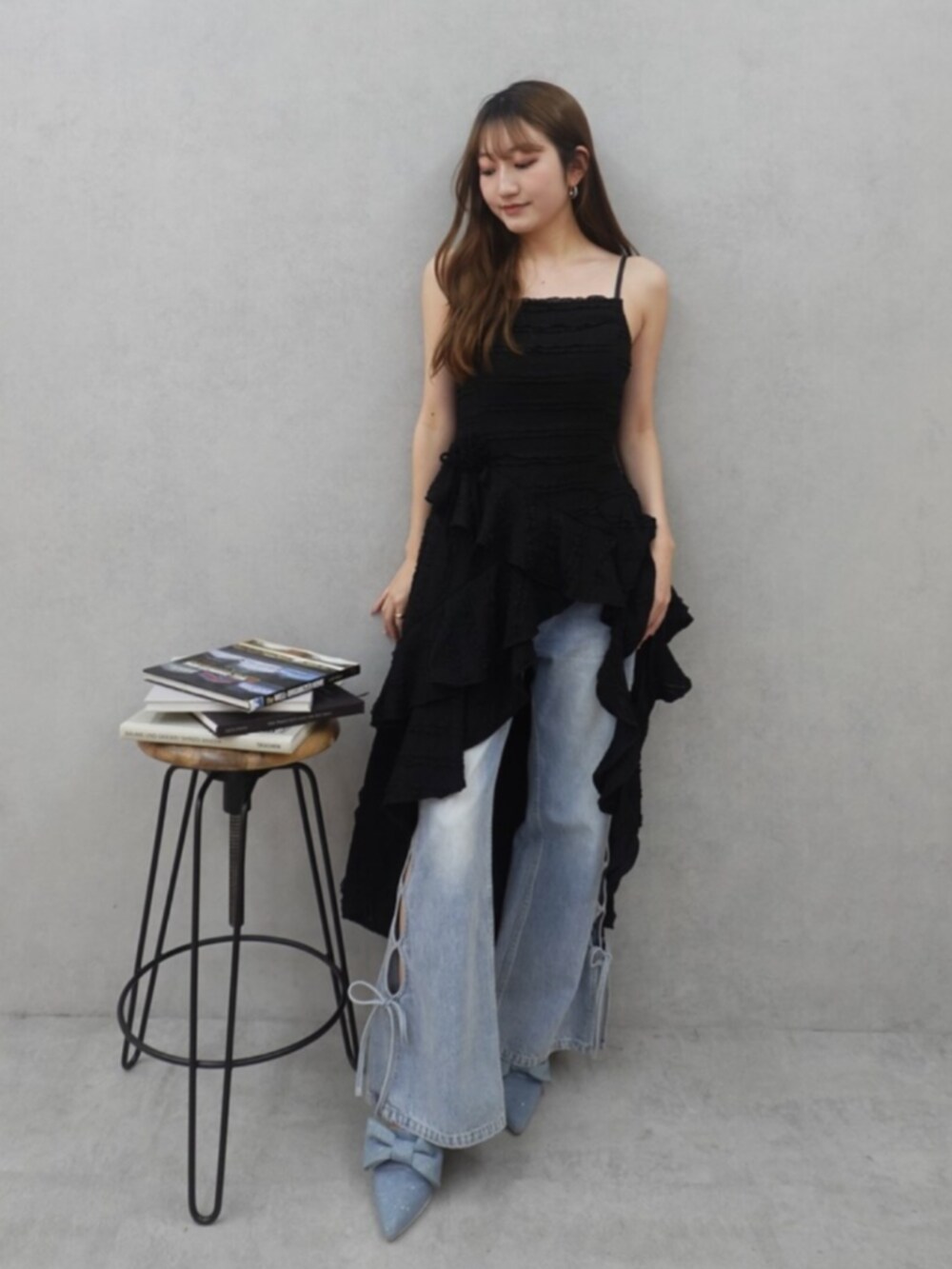 ブラック系のワンピース、ブルー系のデニムパンツ、ブルー系のサンダルを着用したレディースの春コーディネートの2枚目の写真