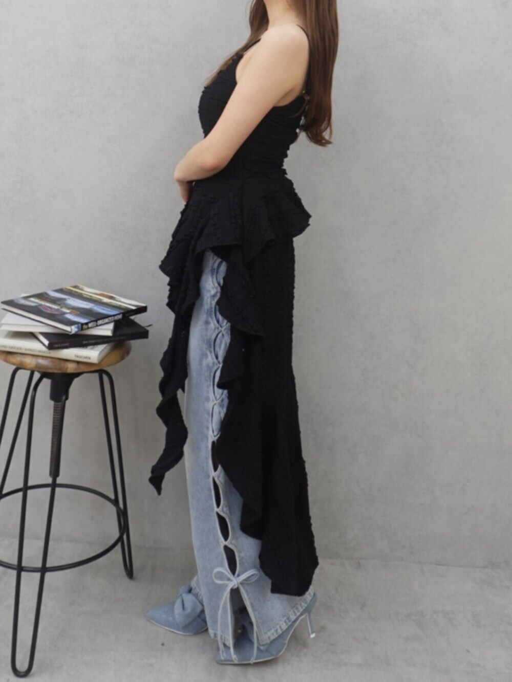 ブラック系のワンピース、ブルー系のデニムパンツ、ブルー系のサンダルを着用したレディースの春コーディネートの5枚目の写真