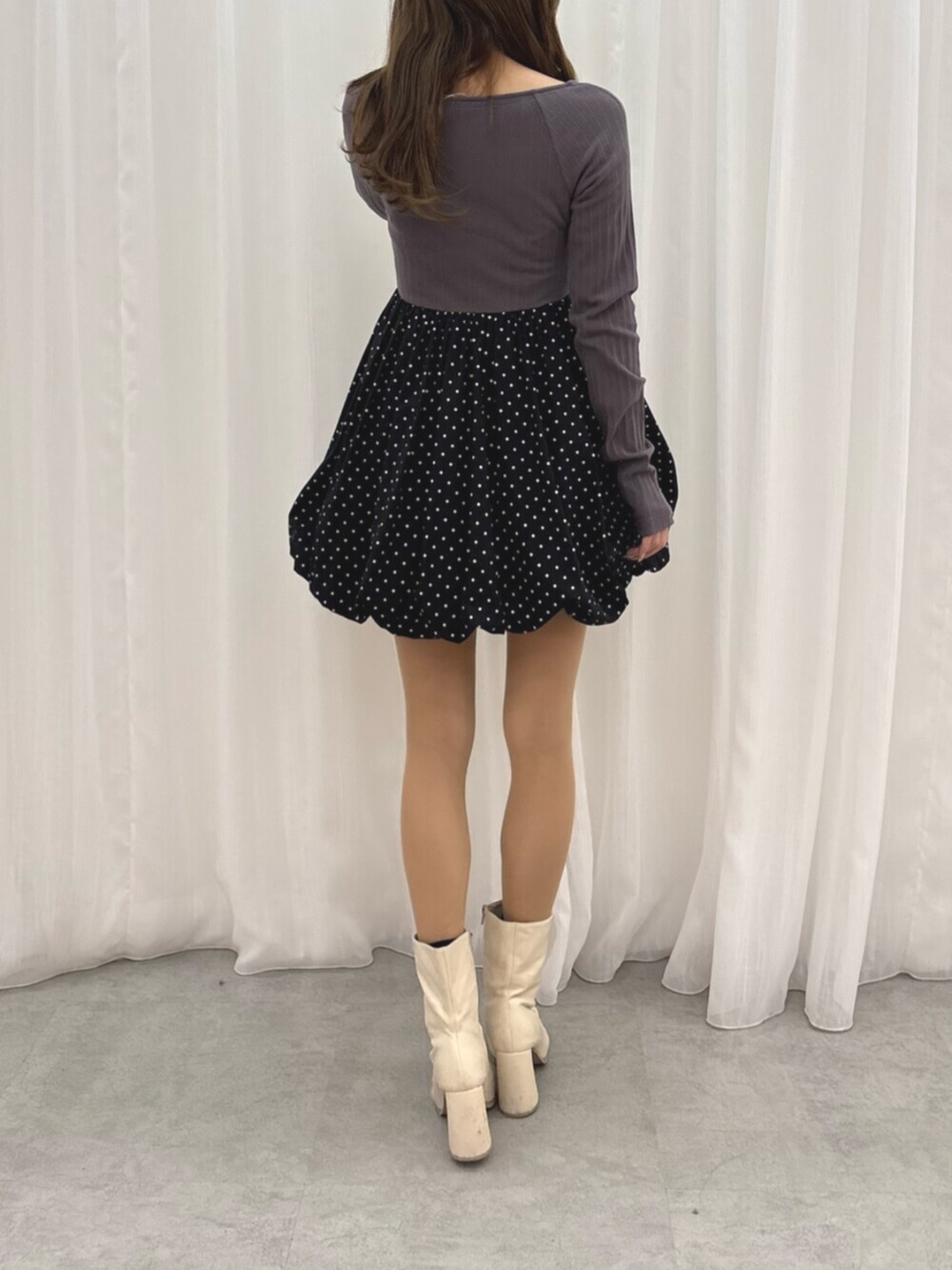 ホワイト系のブーツ、グレー系のワンピースを着用したレディースの冬コーディネートの4枚目の写真