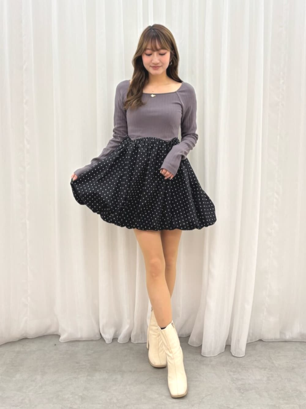 ホワイト系のブーツ、グレー系のワンピースを着用したレディースの冬コーディネートの2枚目の写真