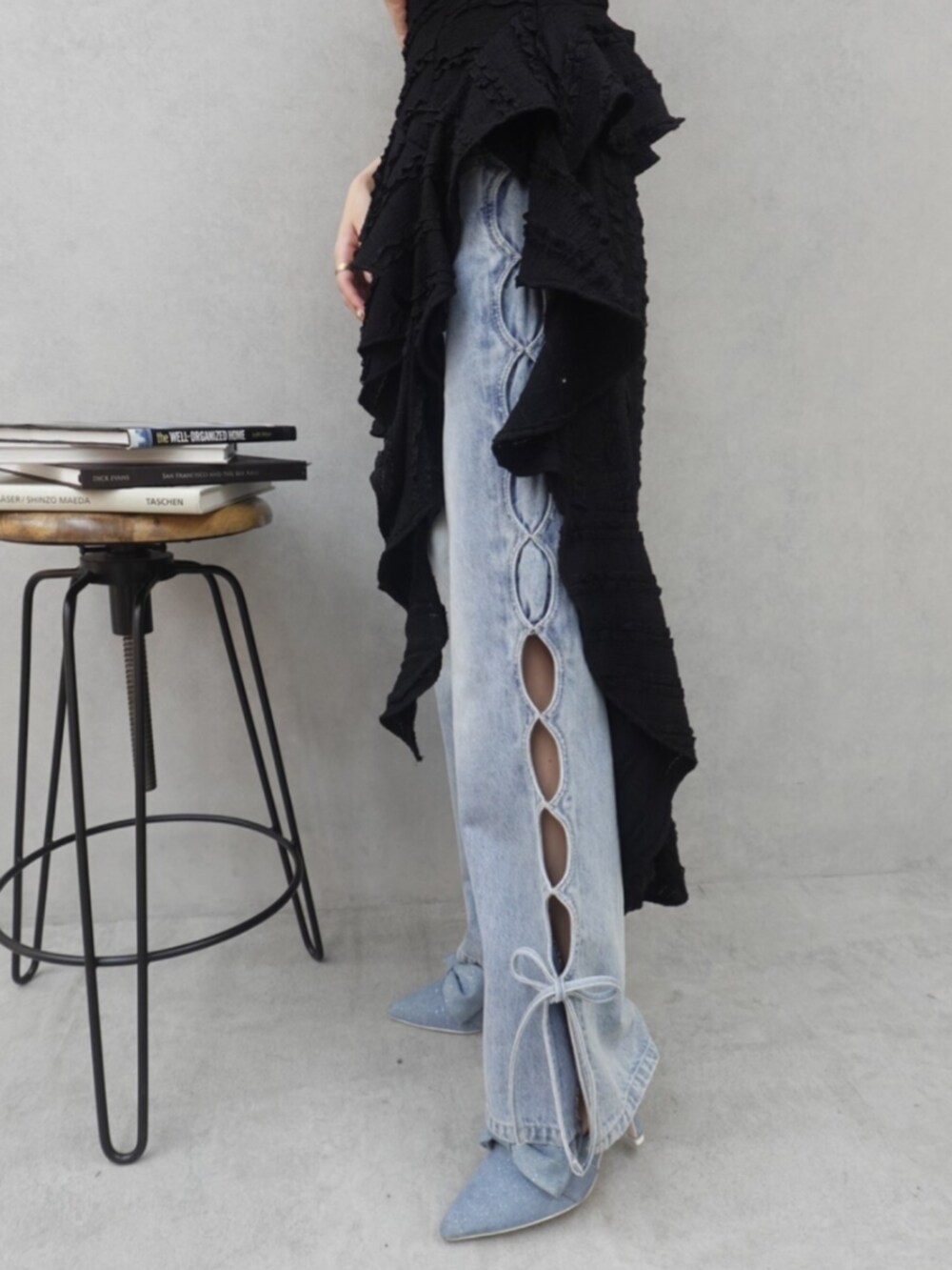 ブラック系のワンピース、ブルー系のデニムパンツ、ブルー系のサンダルを着用したレディースの春コーディネートの4枚目の写真