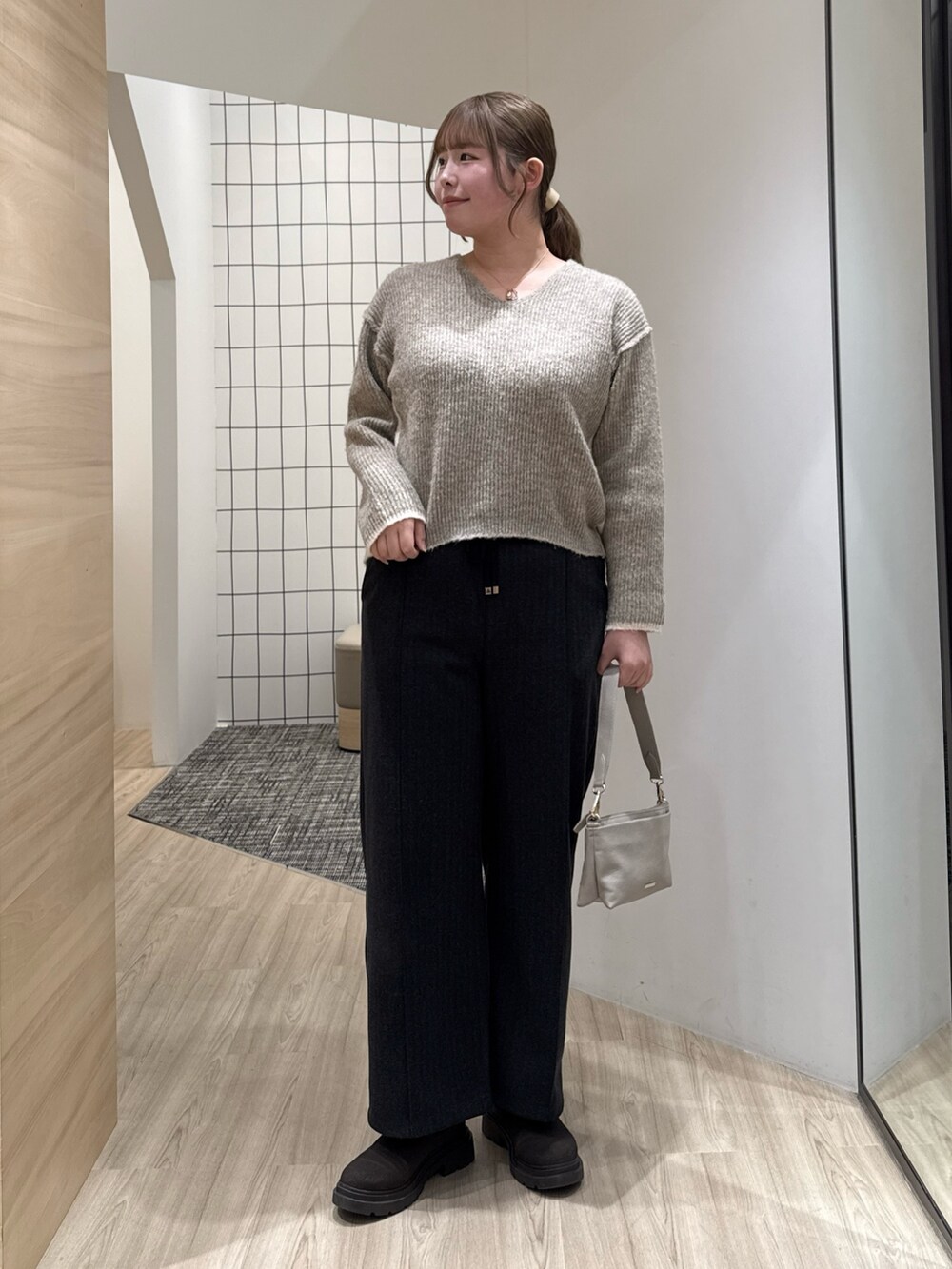 ブラウン系のニット/セーター、グレー系のその他パンツを着用したレディースの冬コーディネートの2枚目の写真