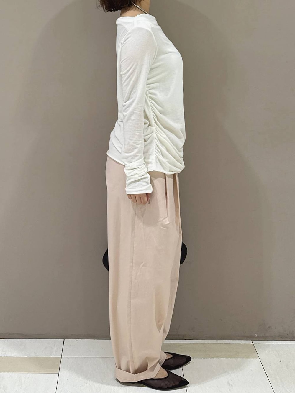 ブラック系のパンプス、ブラック系のハンドバッグ、ホワイト系のTシャツ/カットソーを着用したレディースの冬コーディネートの2枚目の写真