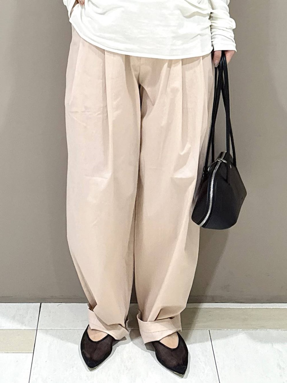 ブラック系のパンプス、ブラック系のハンドバッグ、ホワイト系のTシャツ/カットソーを着用したレディースの冬コーディネートの6枚目の写真