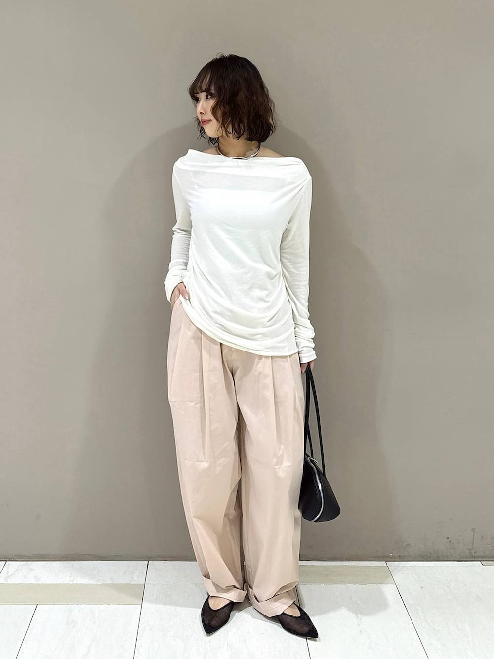 ブラック系のパンプス、ブラック系のハンドバッグ、ホワイト系のTシャツ/カットソーを着用したレディースの冬コーディネートの8枚目の写真