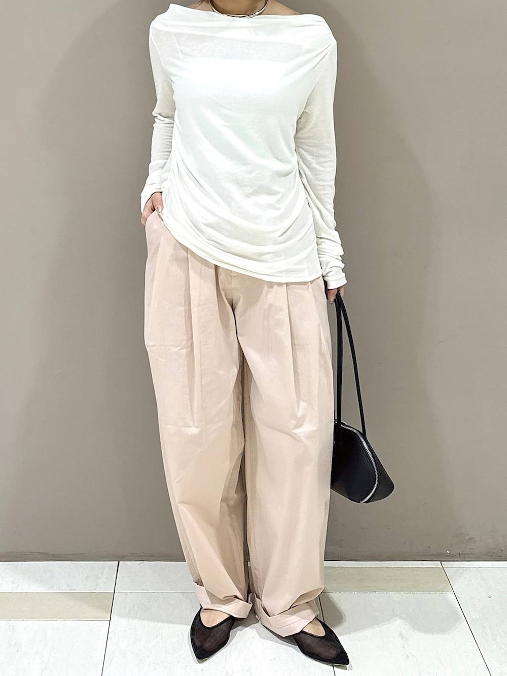 ブラック系のパンプス、ブラック系のハンドバッグ、ホワイト系のTシャツ/カットソーを着用したレディースの冬コーディネートの4枚目の写真