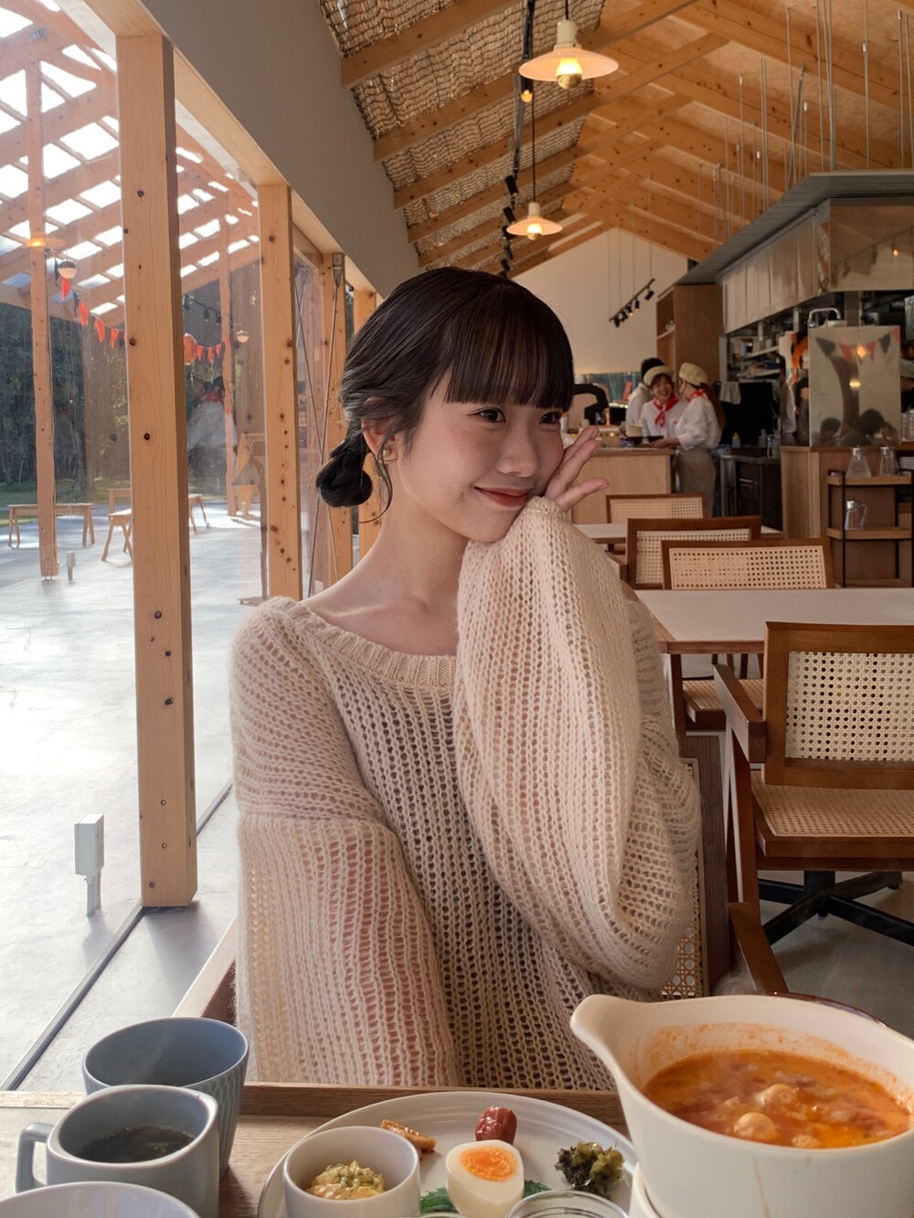 ホワイト系のニット/セーター、ブラウン系のワンピースを着用したレディースの夏コーディネートの2枚目の写真