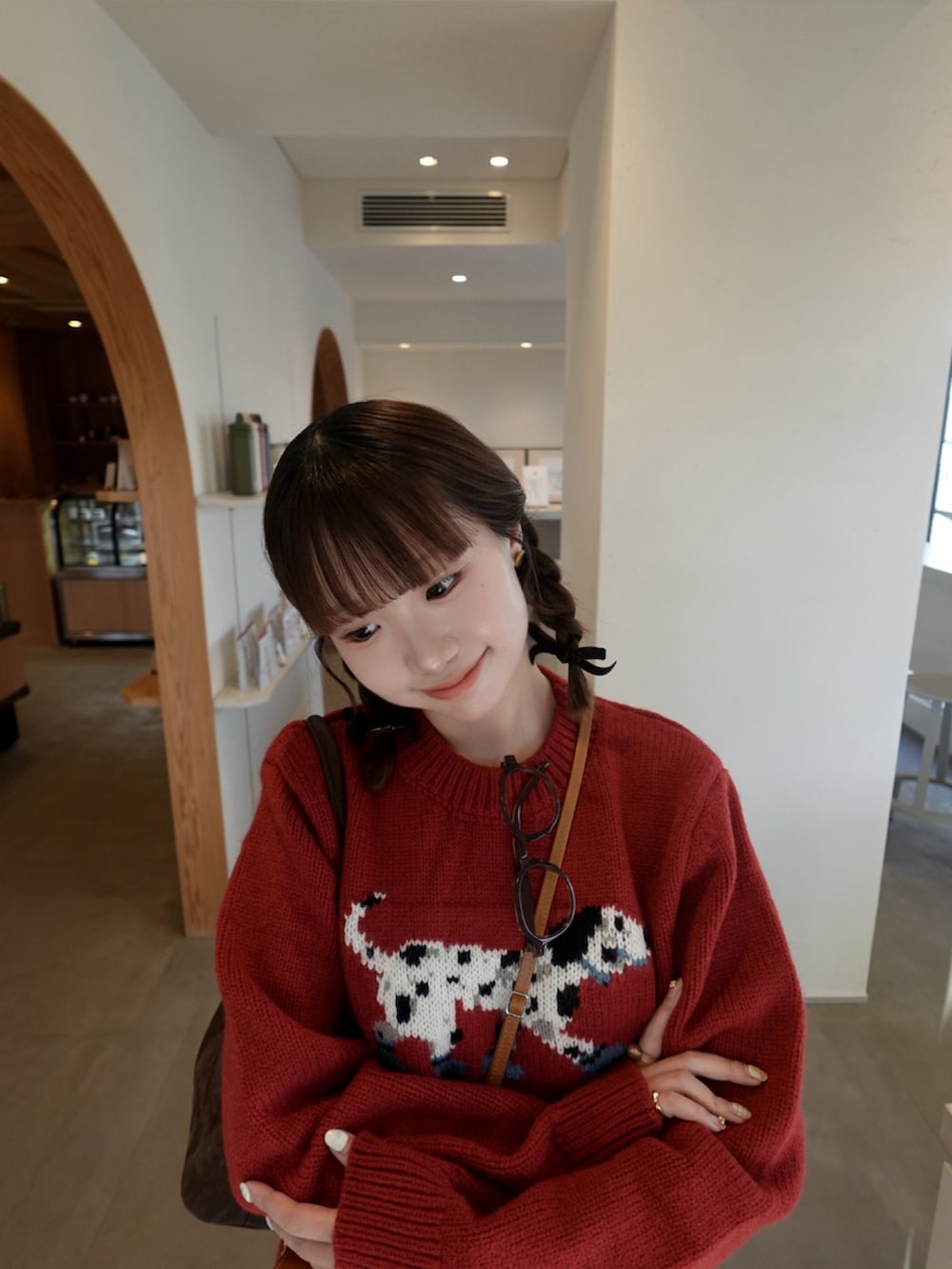 レッド系のニット/セーター、ブラウン系のその他パンツ、ブラウン系のブーツを着用したレディースの冬コーディネートの2枚目の写真