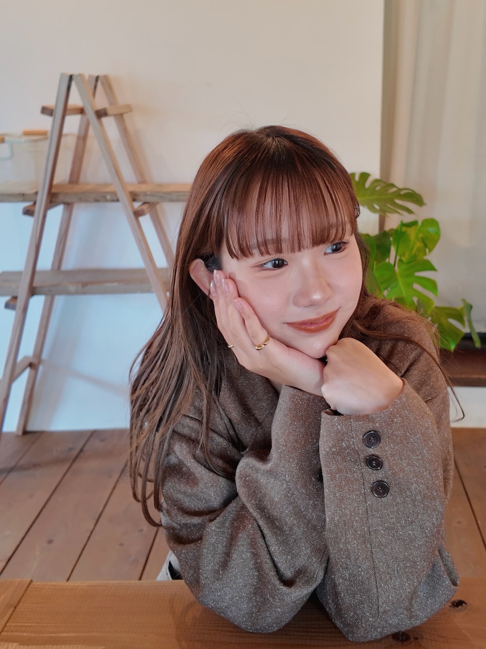 ブルー系のデニムパンツ、ブラウン系のスニーカー、ホワイト系のキャミソールを着用したレディースの秋コーディネートの2枚目の写真