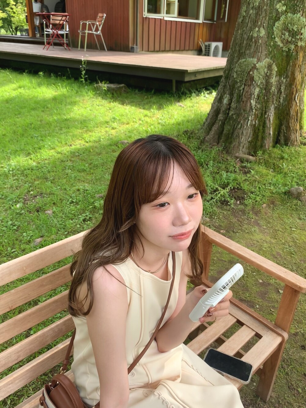 ホワイト系のワンピース/ドレス、グレー系のハンドバッグ、ベージュ系のパンプスを着用したレディースの夏コーディネートの3枚目の写真