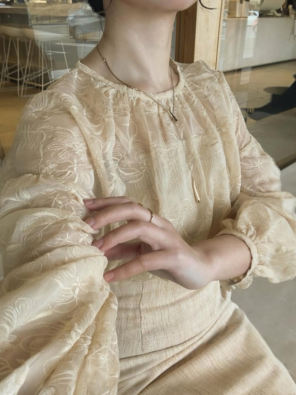 ベージュ系のトップス、ベージュ系のスカート、ホワイト系のバッグを着用したレディースの春コーディネートの3枚目の写真