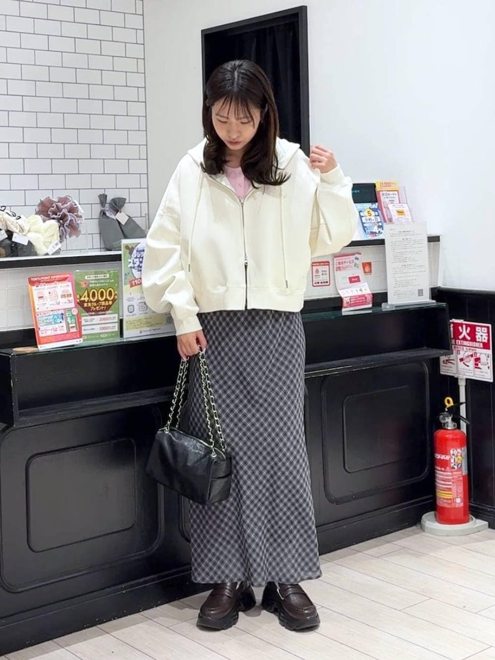 ピンク系のニット/セーター、ベージュ系のパーカー、ブラック系のショルダーバッグを着用したレディースの冬コーディネートの4枚目の写真