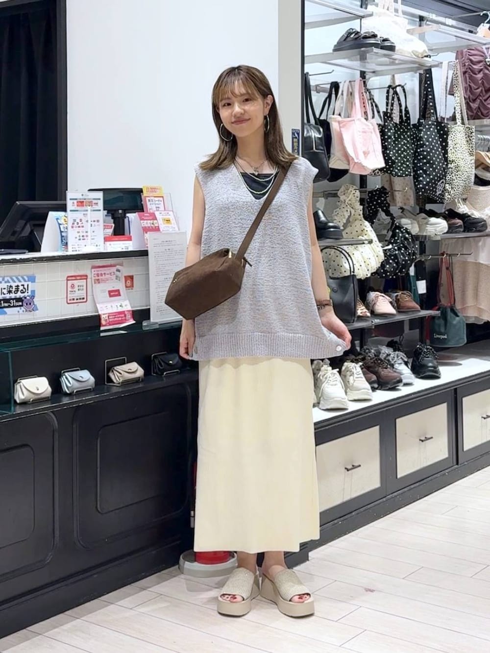 ホワイト系のスカート、ホワイト系のサンダル、ブラウン系のショルダーバッグを着用したレディースの夏コーディネートの4枚目の写真