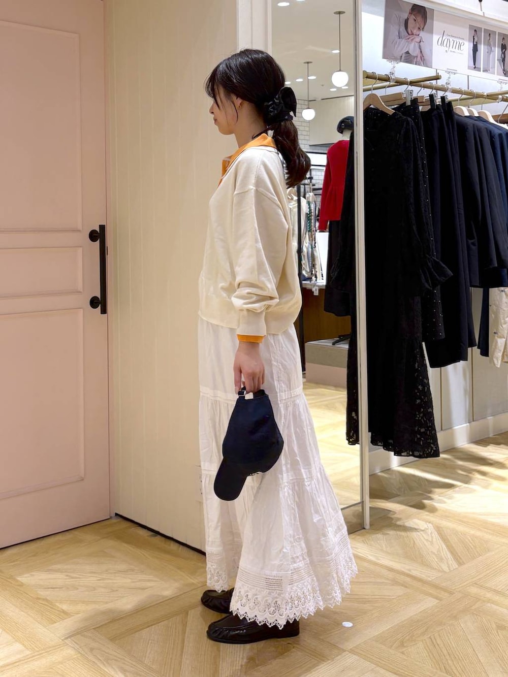 ブラック系のローファー、ホワイト系のスカート、ホワイト系のニット/セーターを着用したレディースの春コーディネートの2枚目の写真