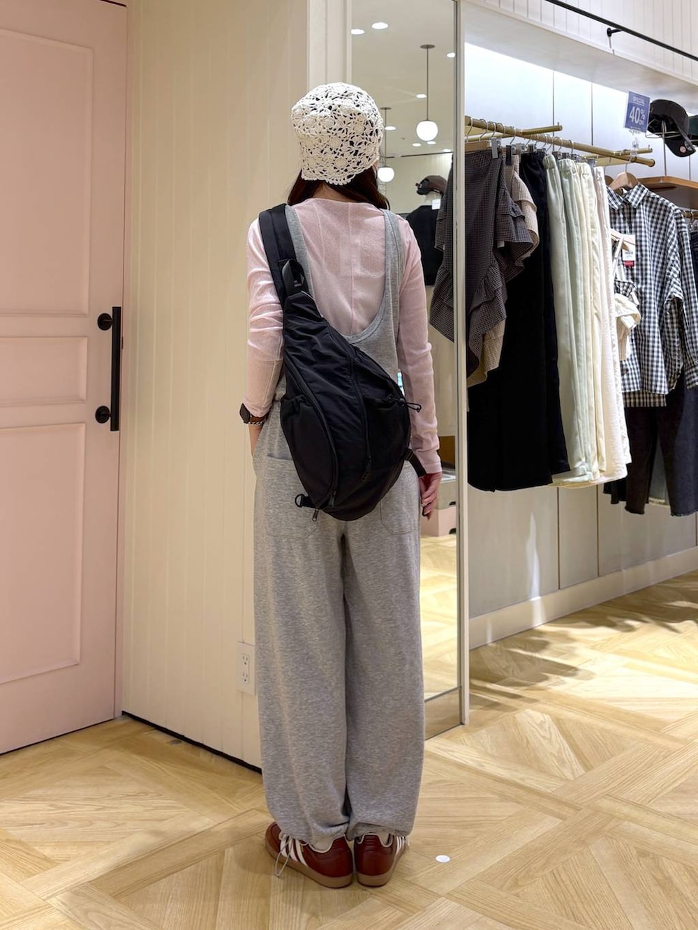 ブラック系のショルダーバッグ、ピンク系のTシャツ/カットソー、グレー系のサロペット/オーバーオールを着用したレディースの春コーディネートの3枚目の写真