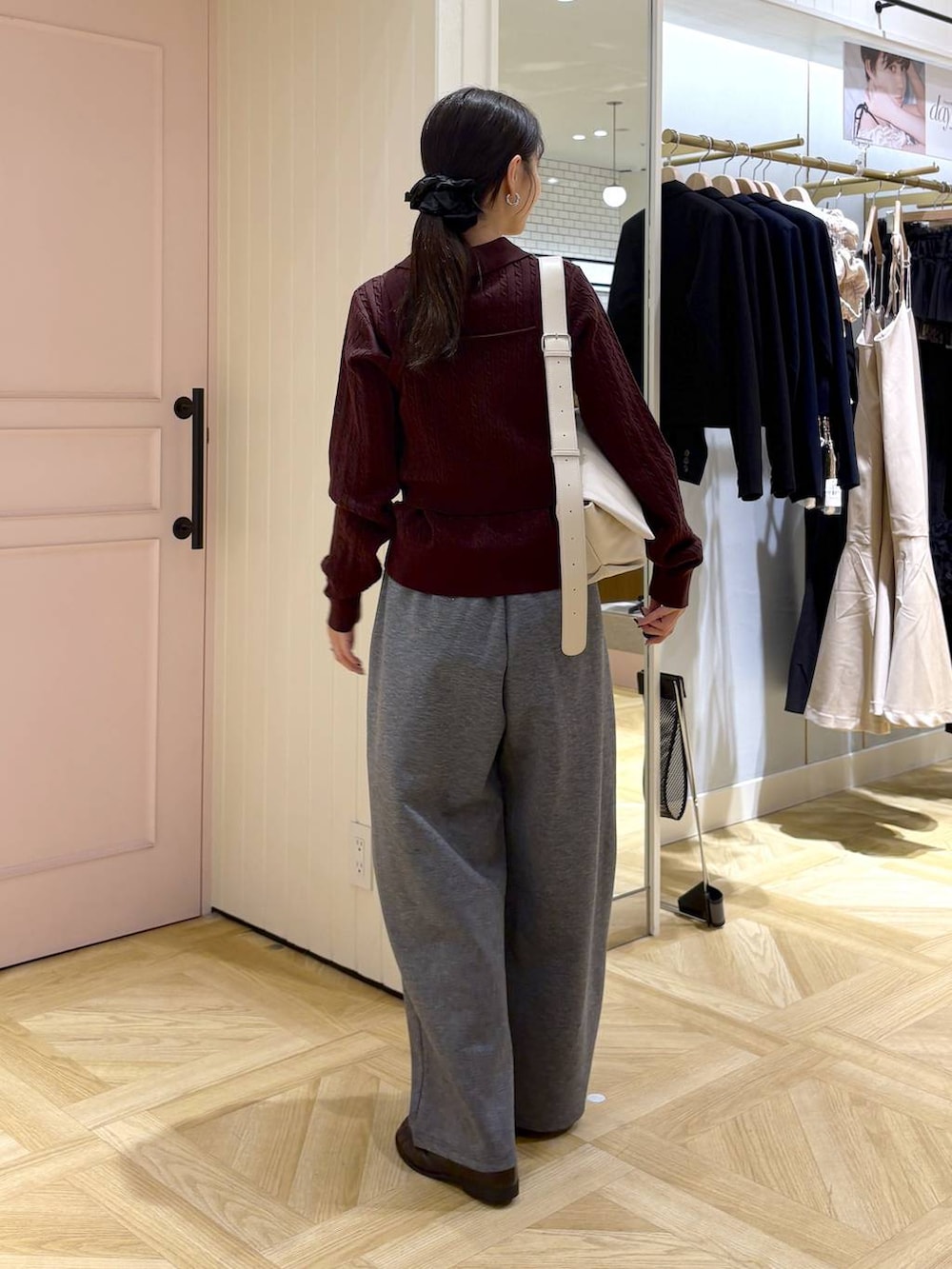 ホワイト系のショルダーバッグ、ブラウン系のローファー、グレー系のスウェットパンツを着用したレディースの秋コーディネートの3枚目の写真