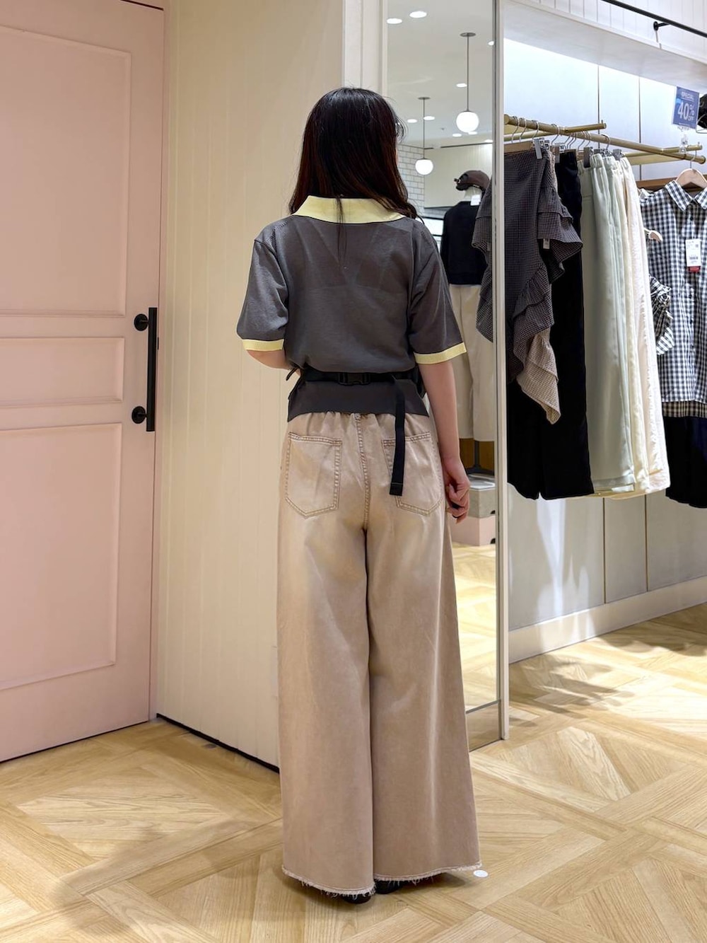 オレンジ系のデニムパンツ、ブラック系のボディバッグ/ウエストポーチ、ブラック系のローファーを着用したレディースの春コーディネートの3枚目の写真