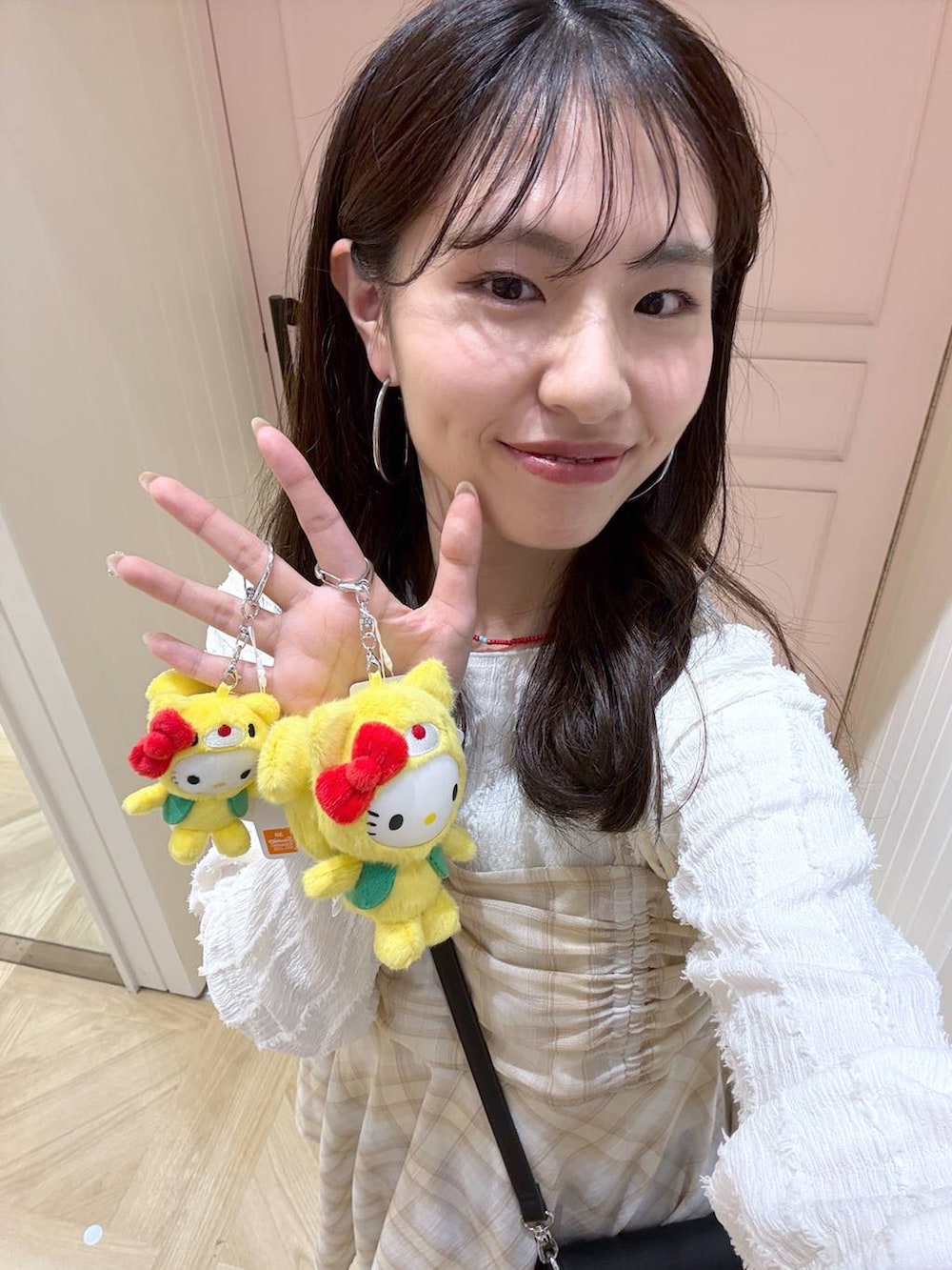 ベージュ系のTシャツ/カットソー、ベージュ系のその他トップス、ブラック系のキーホルダーを着用したレディースの春コーディネートの2枚目の写真