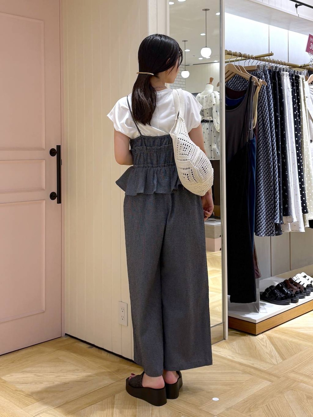 ホワイト系のTシャツ/カットソー、ブラック系のサンダル、ブルー系のサロペット/オーバーオールを着用したレディースの夏コーディネートの3枚目の写真