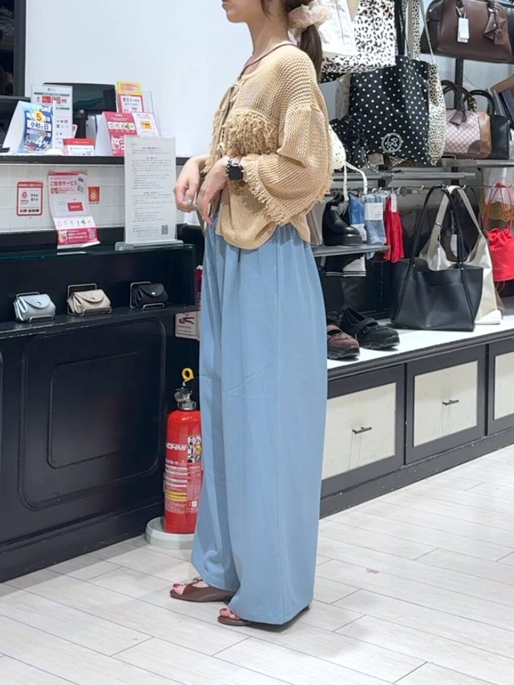 ブラウン系のサンダル、ベージュ系のカーディガン/ボレロ、ベージュ系のショルダーバッグを着用したレディースの夏コーディネートの2枚目の写真