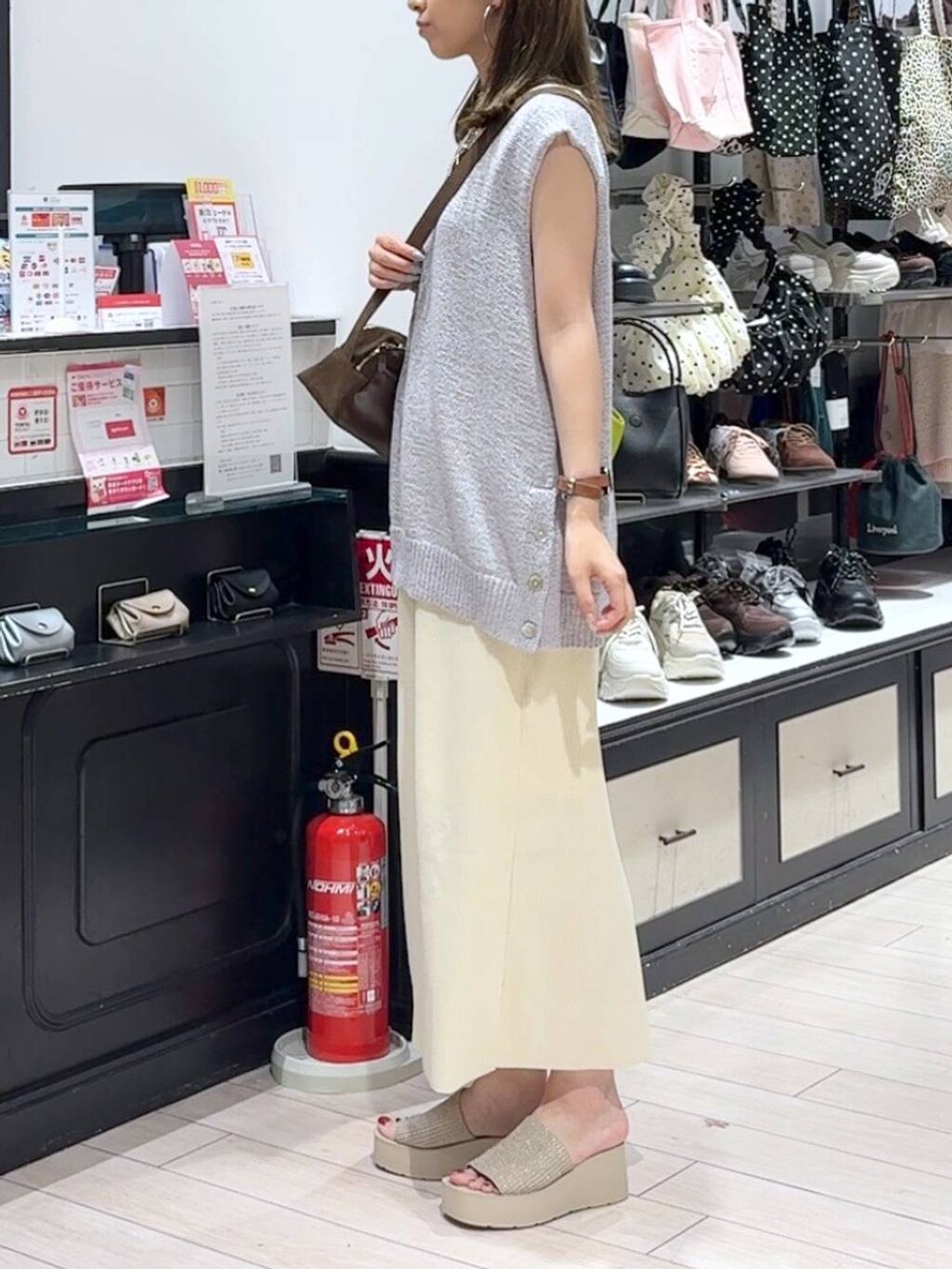 ホワイト系のスカート、ホワイト系のサンダル、ブラウン系のショルダーバッグを着用したレディースの夏コーディネートの2枚目の写真