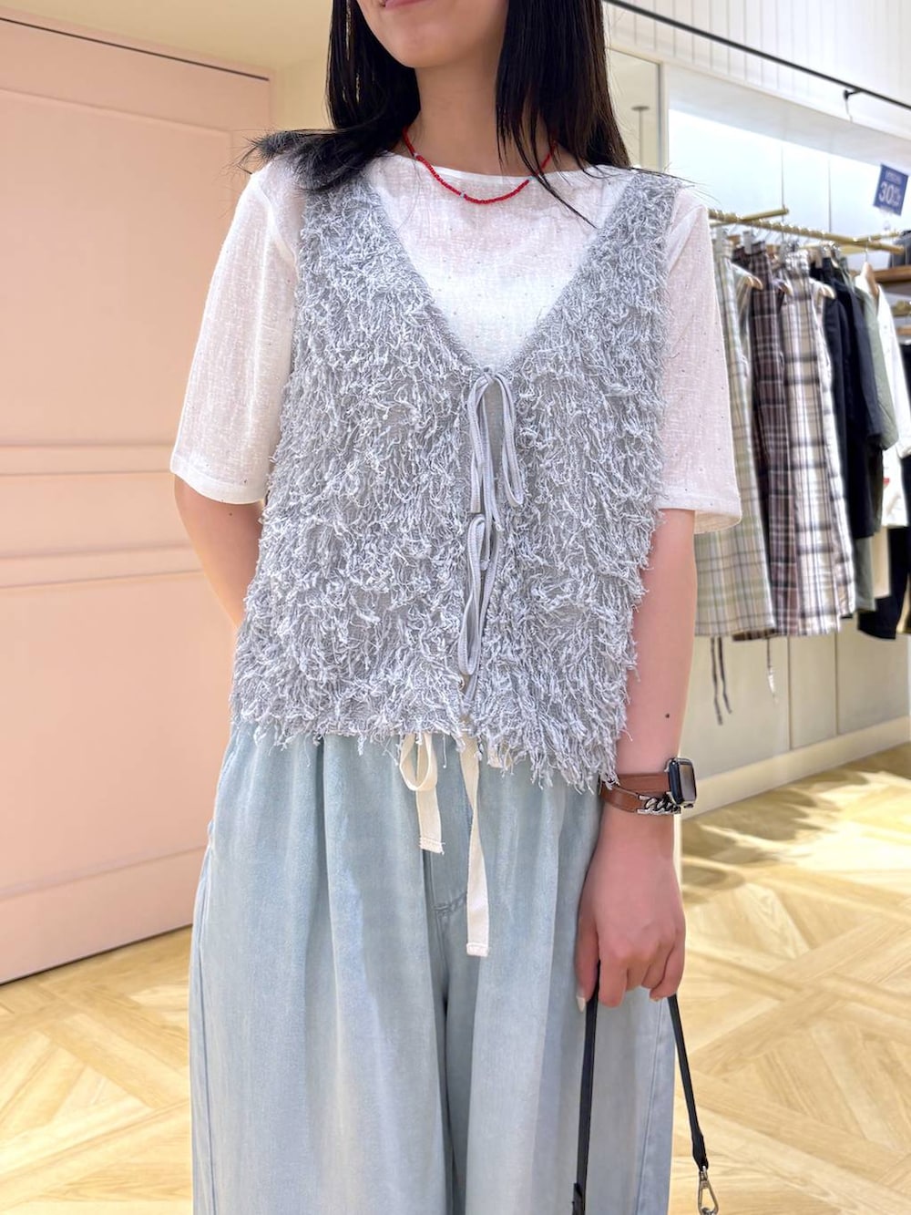 ホワイト系のTシャツ/カットソー、シルバー系のサンダル、グレー系のベストを着用したレディースの夏コーディネートの2枚目の写真