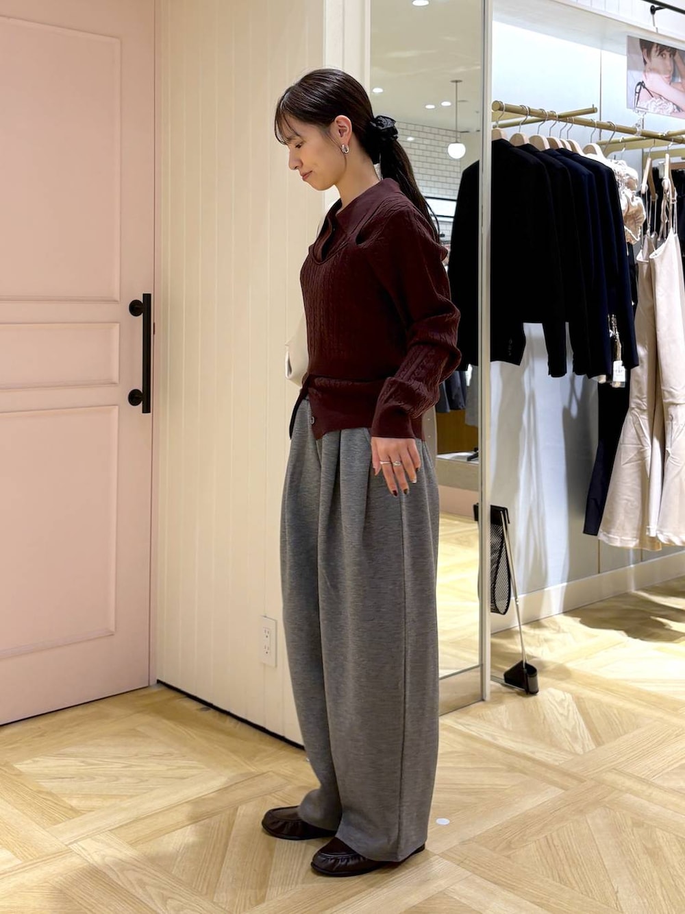 ホワイト系のショルダーバッグ、ブラウン系のローファー、グレー系のスウェットパンツを着用したレディースの秋コーディネートの2枚目の写真