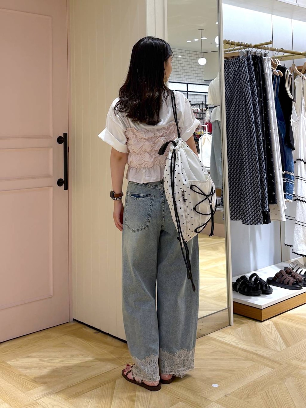 ピンク系のベスト、ブルー系のデニムパンツ、ブラウン系のサンダルを着用したレディースの夏コーディネートの4枚目の写真