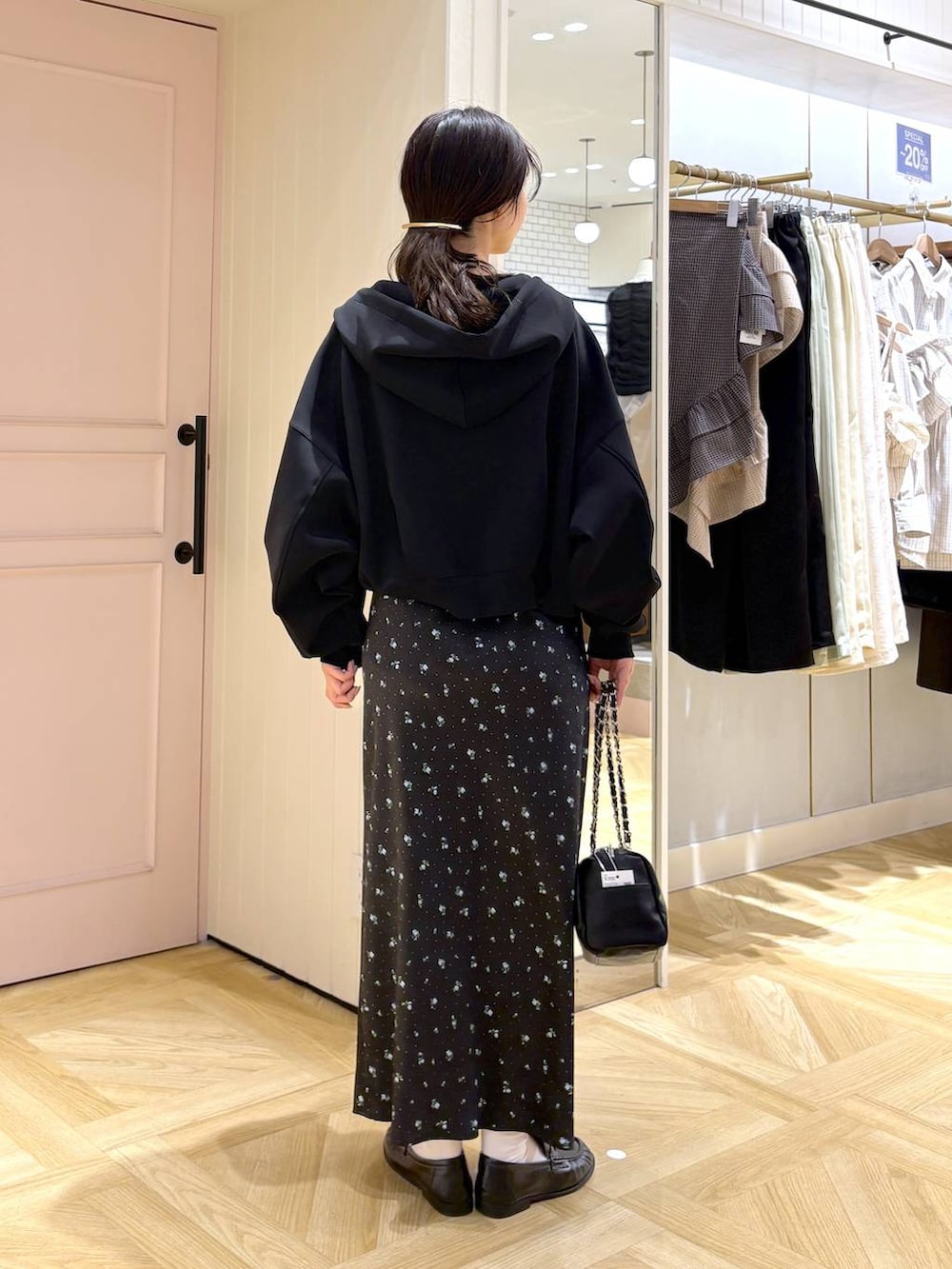 ブラック系のスカート、ブラック系のパーカー、ブラック系のショルダーバッグを着用したレディースの春コーディネートの3枚目の写真